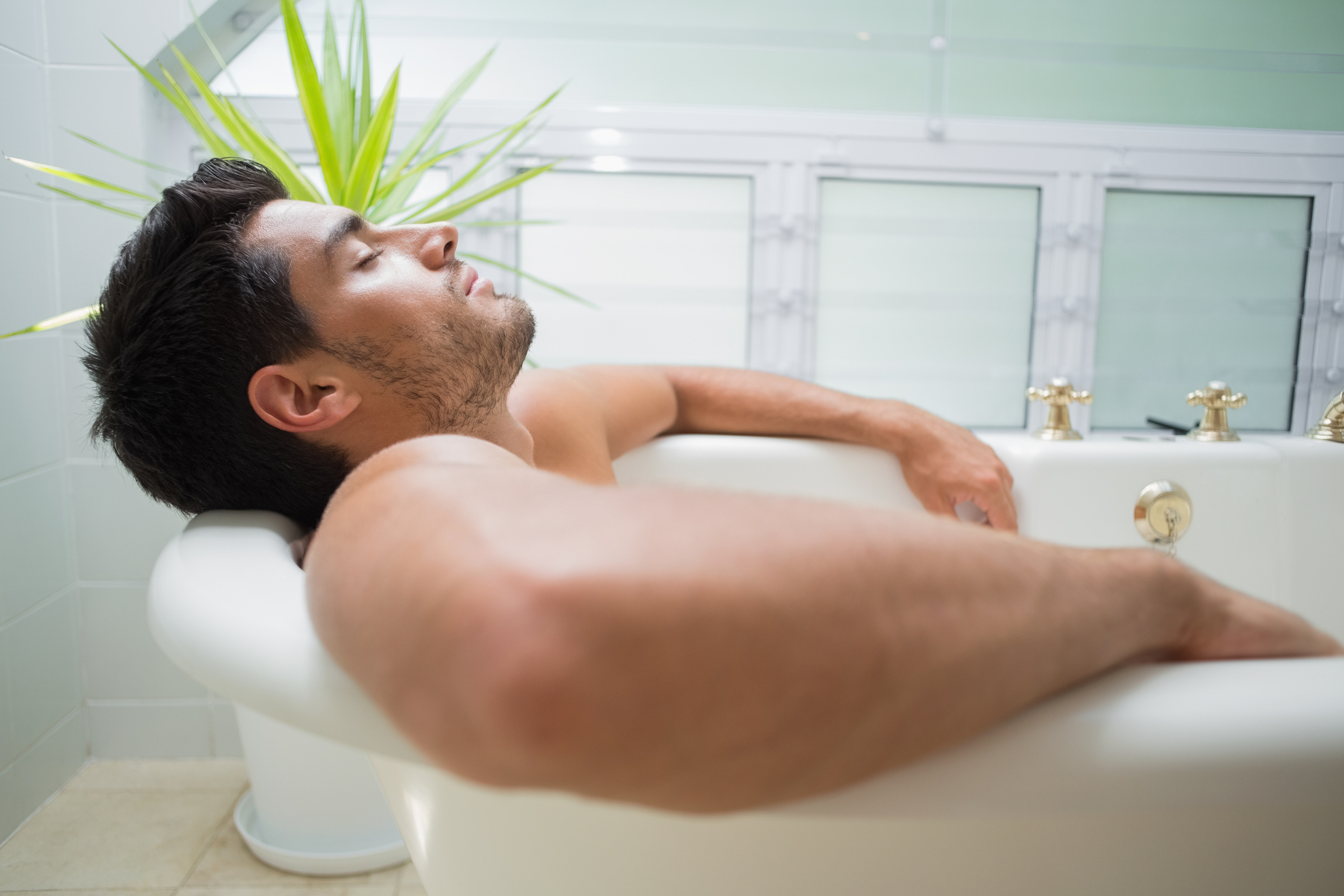 Handsome man relaxing in bath