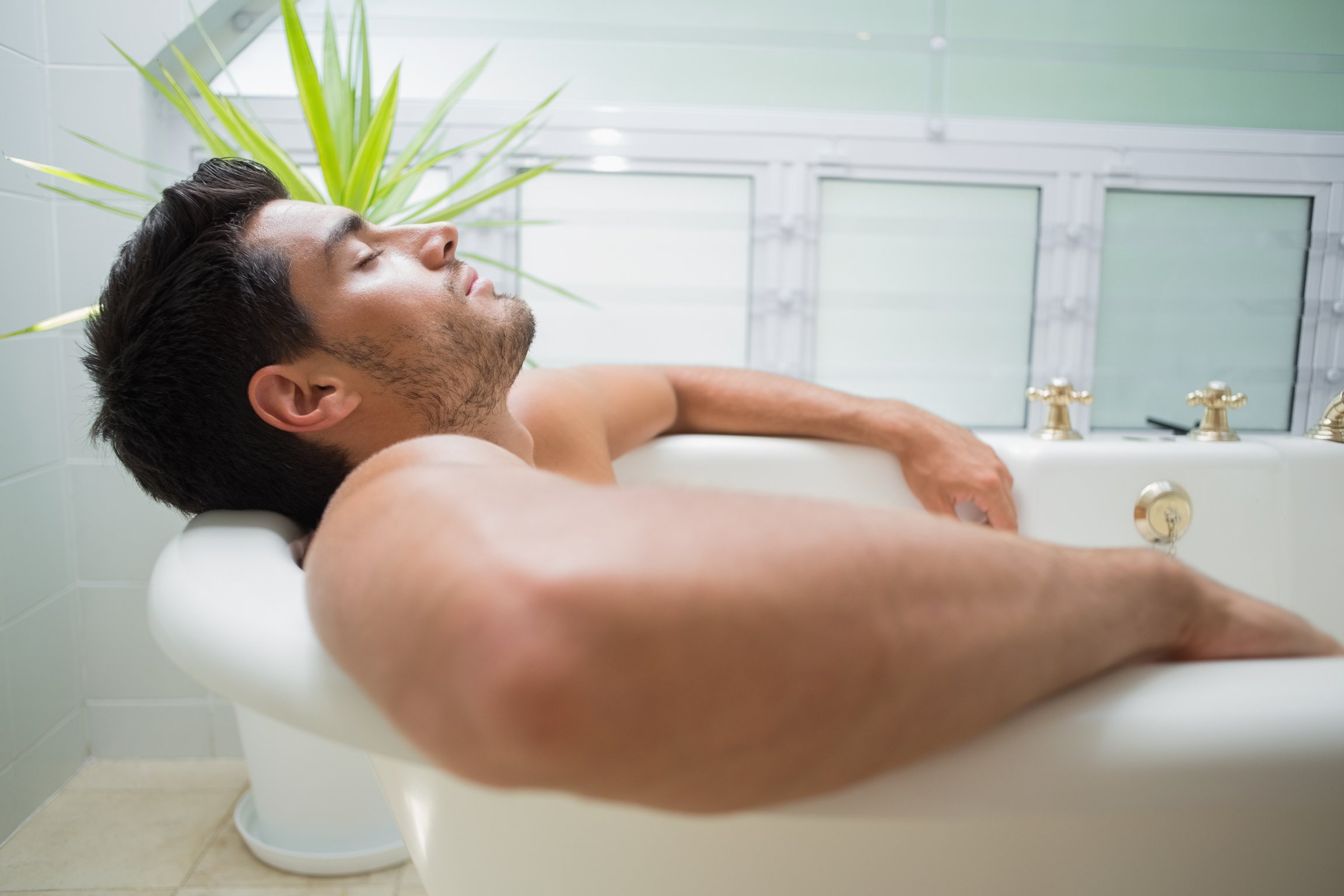 Handsome man relaxing in bath